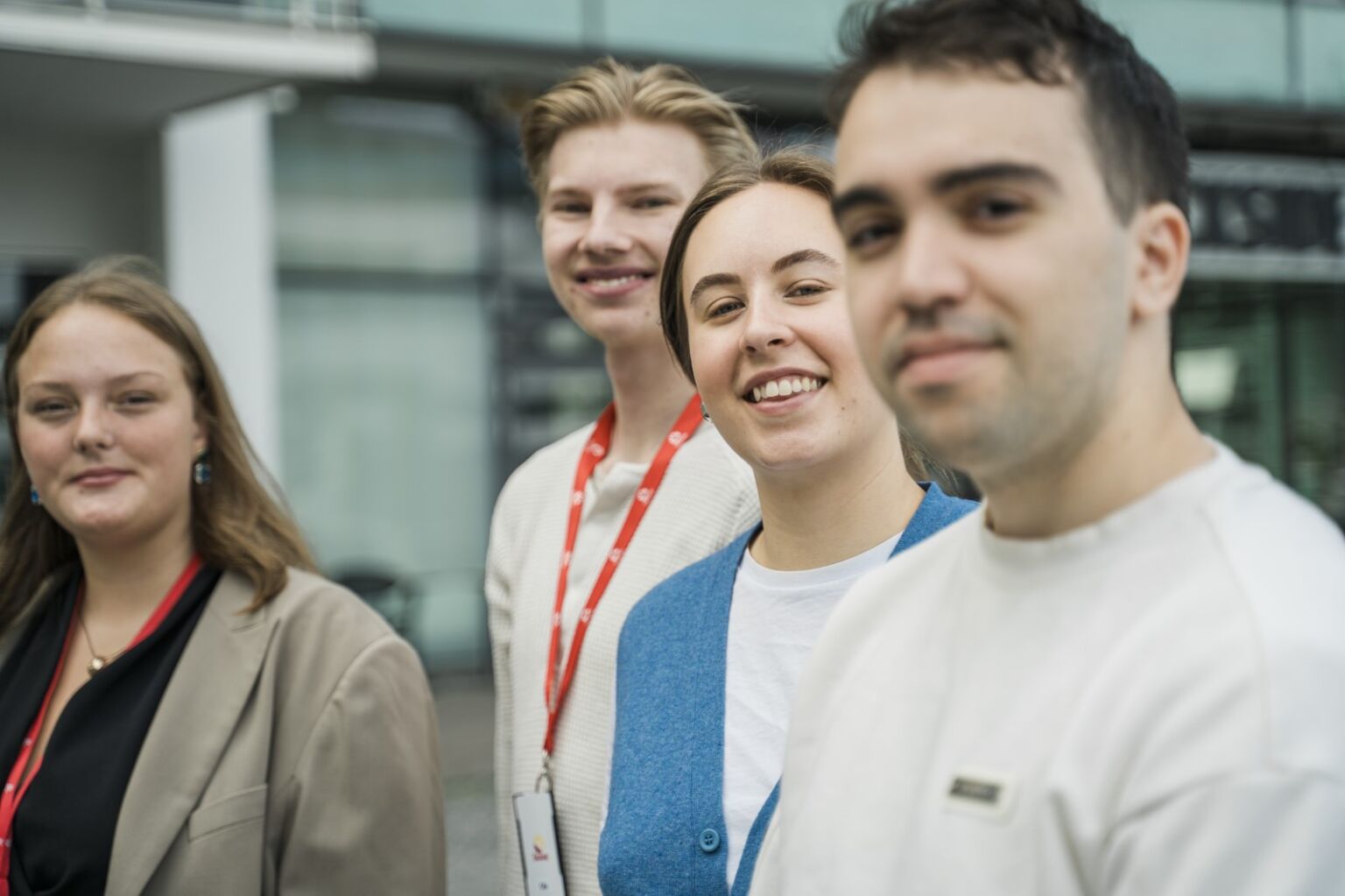 Fyra ungdomar står på rad och tittar in i kameran