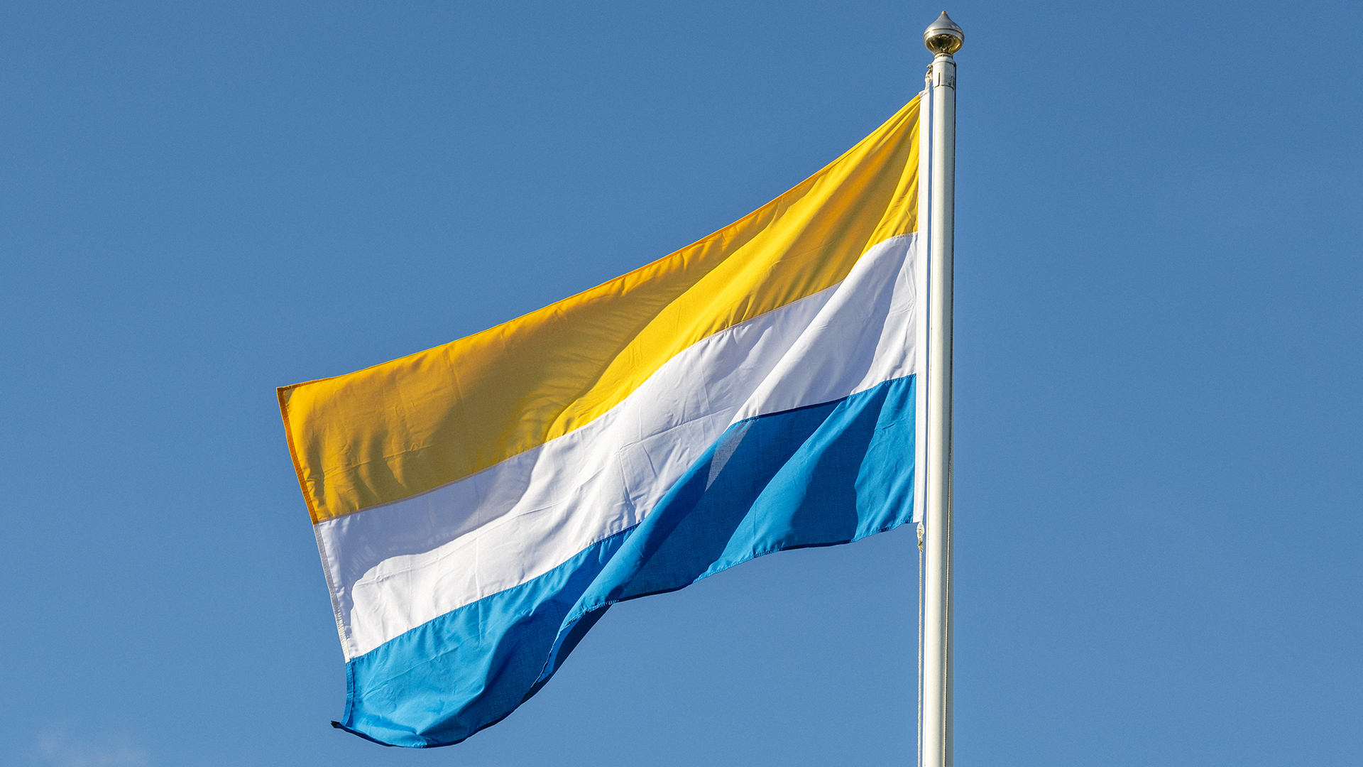 Tornedalens flagga mot en blå himmel