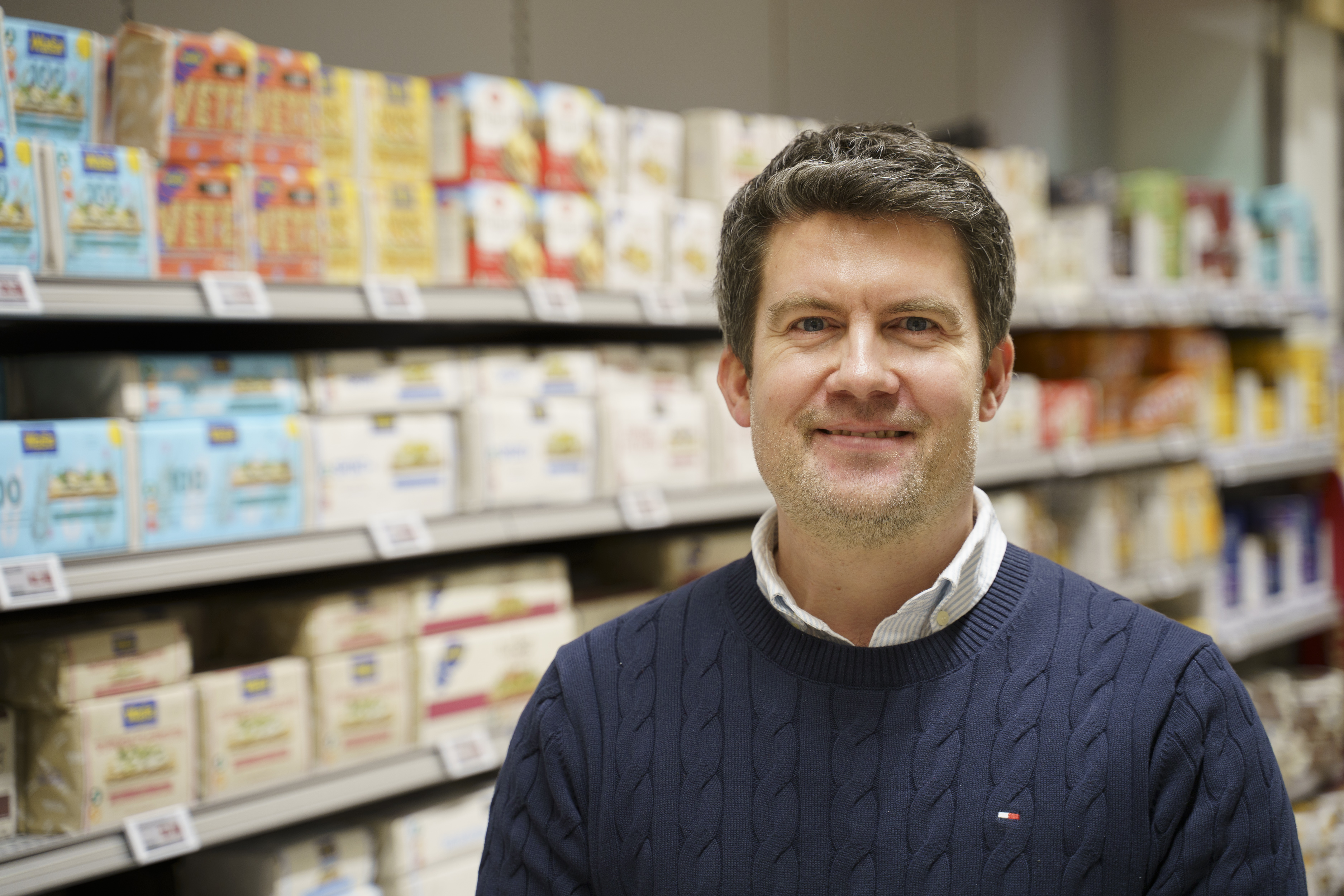 En man står framför en hylla med knäckebröd.