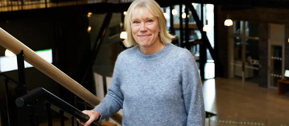 Leende kvinna står i en trappa.
