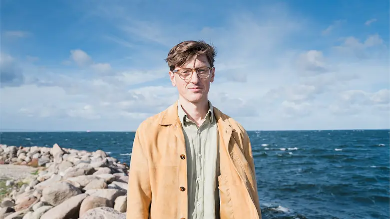 Porträttfoto av psykolog Johannes Malm med havet som bakgrund.