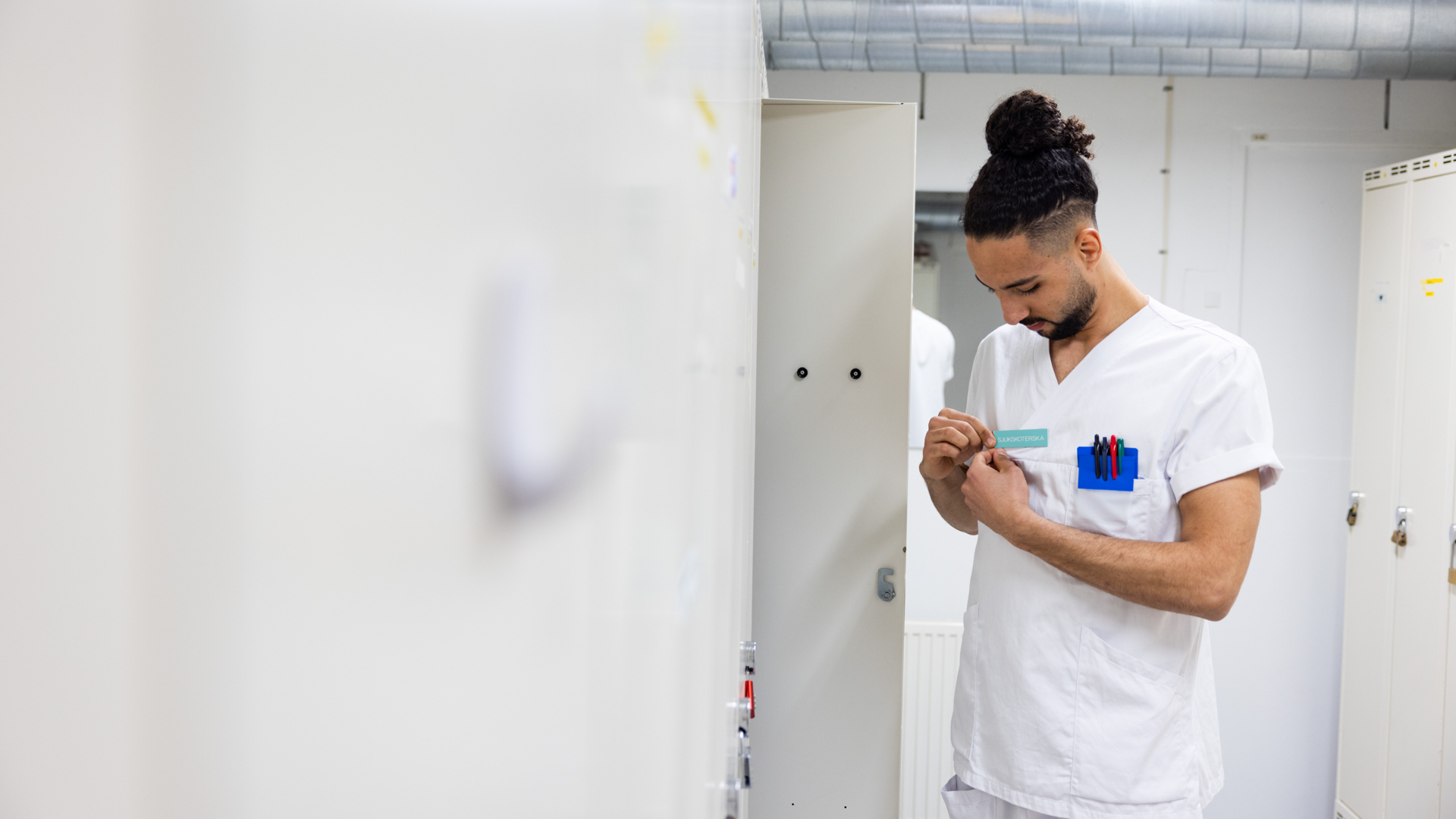 Vårdpersonal sätter på sig en namnbricka