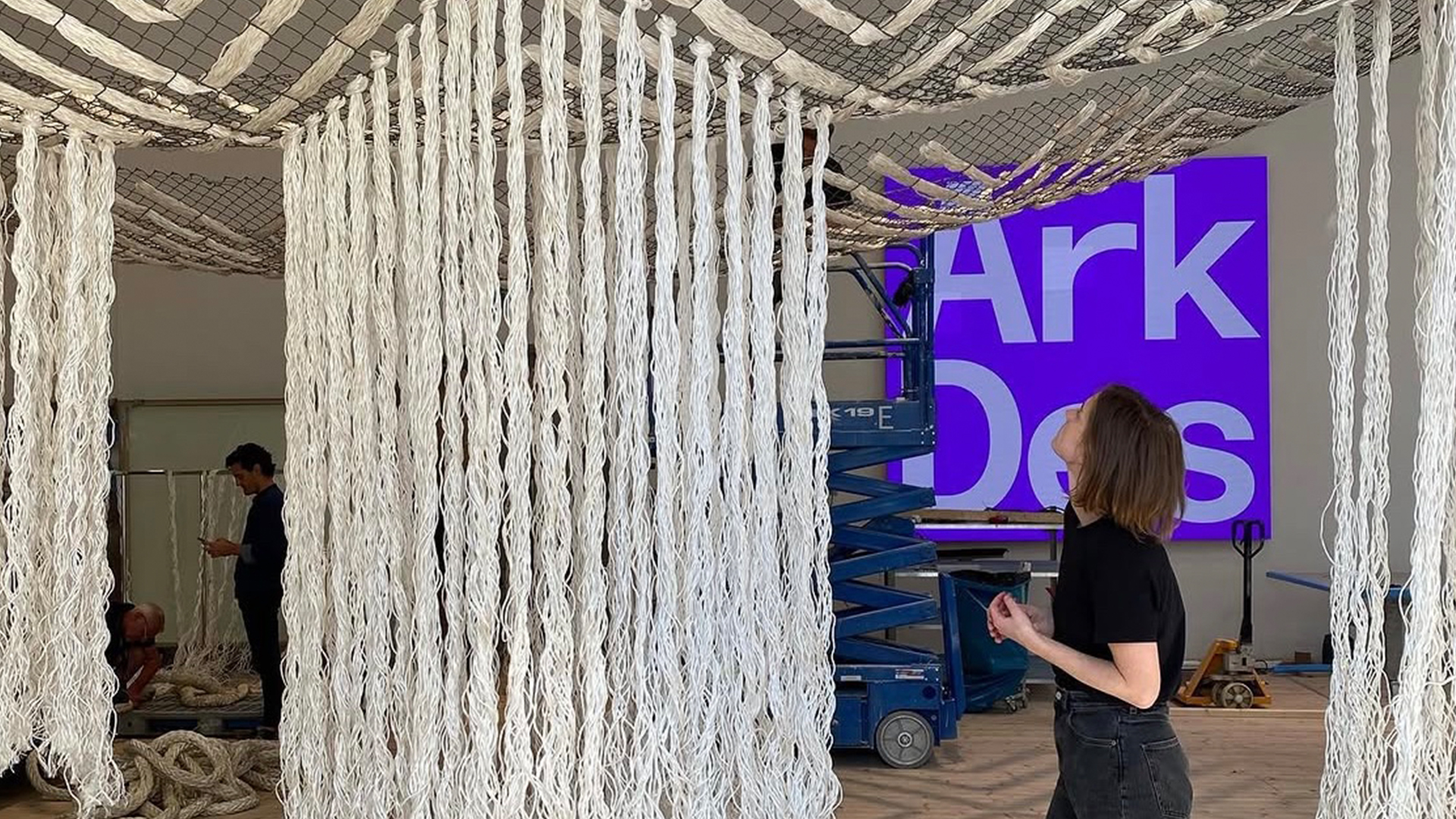 Tygstycken hänger ner i en utställningshall. 