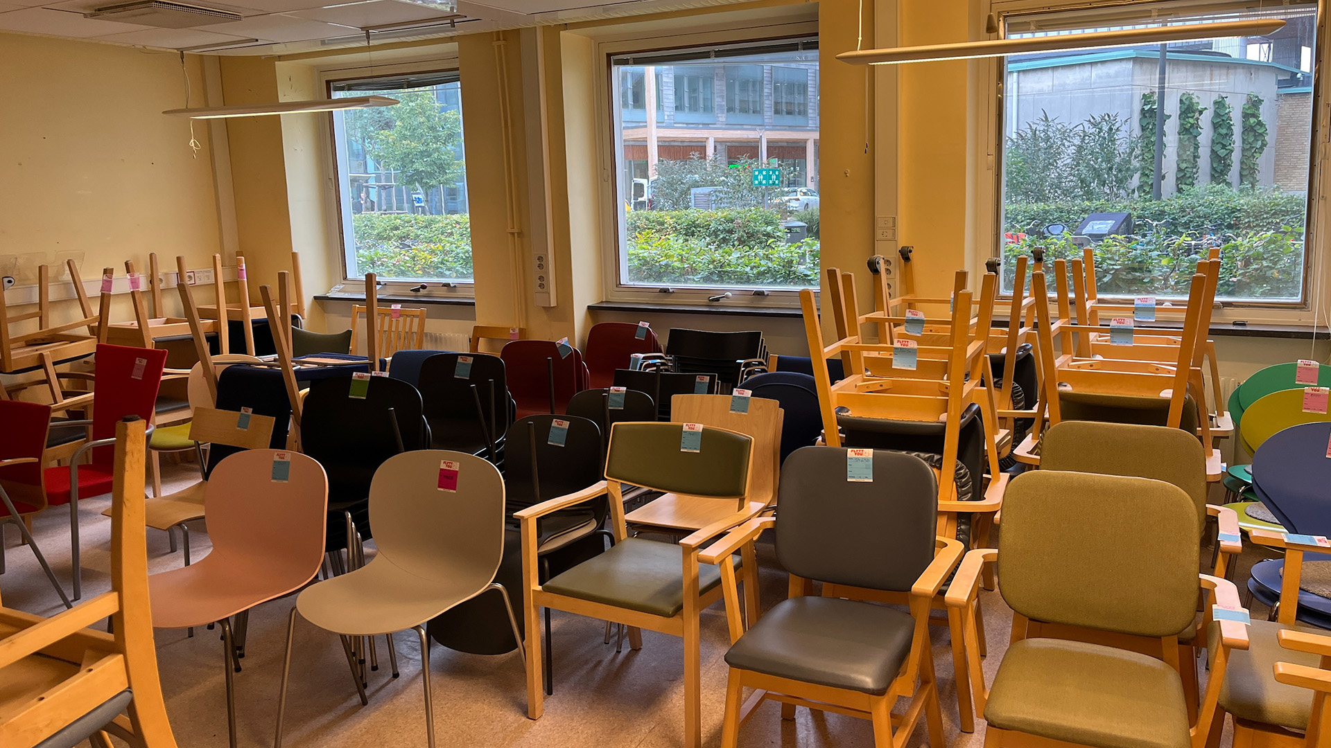 En stor mängd stolar står i ett förråd. 