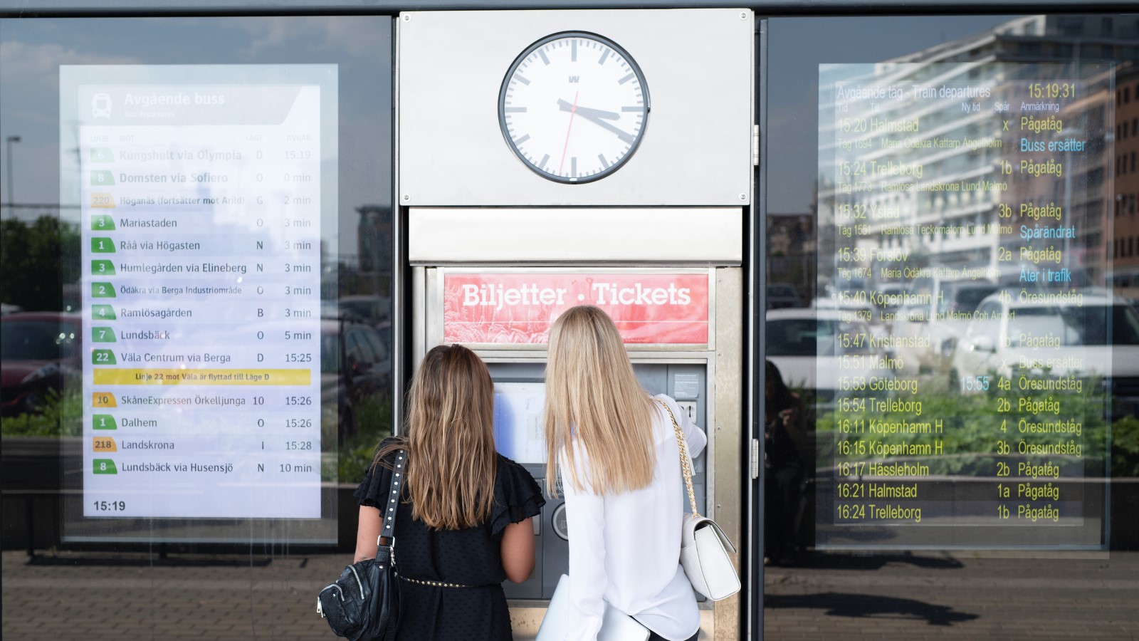 Två tjejer köper biljetter i en biljettautomat