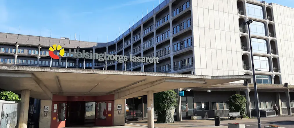 entré med skylt Helsingborgs lasarett till en byggnad med grå betongfasad