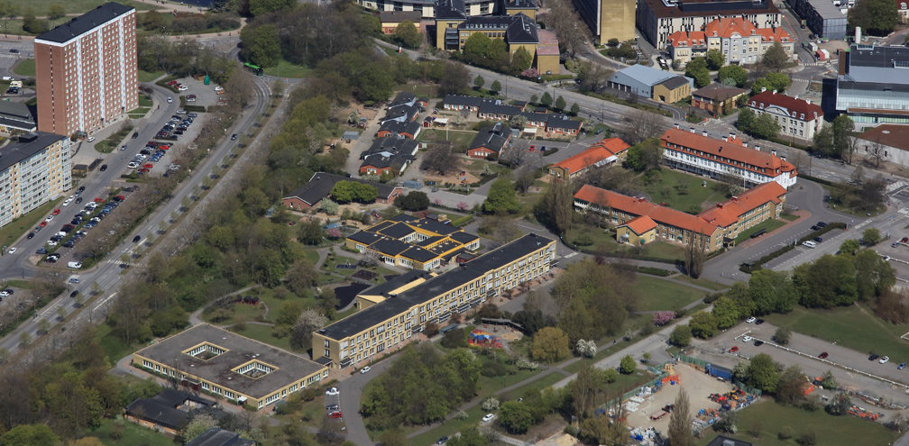 flygbild över ett område med bebyggelse, bilvägar och växtlighet