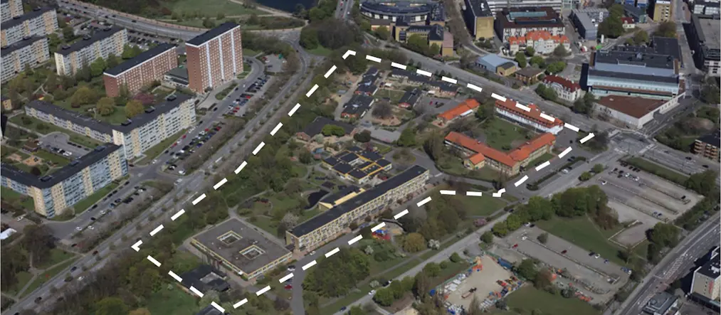 flygbild över stadsområde med bebyggelse, vit streckad linje ramar in ett område i mitten av bilden