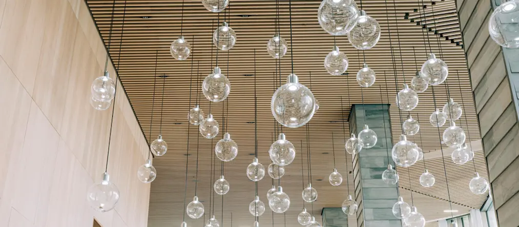 Flera glasglober hänger ner från ett träbeklätt inomhustak