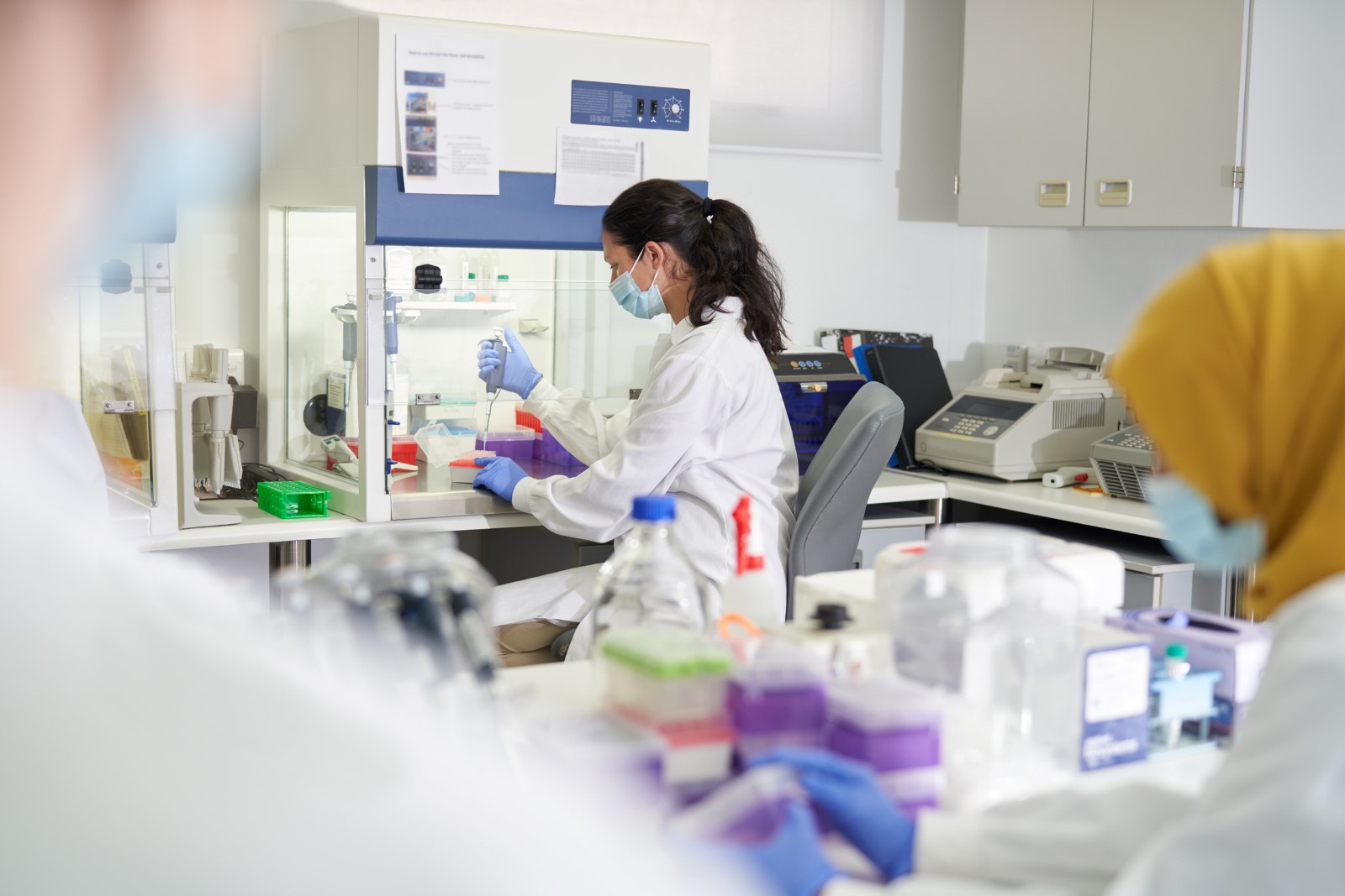 Kvinna i labbkläder arbetar i ett laboratorium.