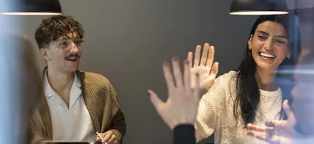 Flera personer sitter runt ett bort och pratar