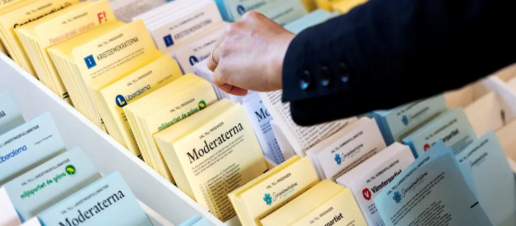 En hand sträcker sig efter röstlappar.